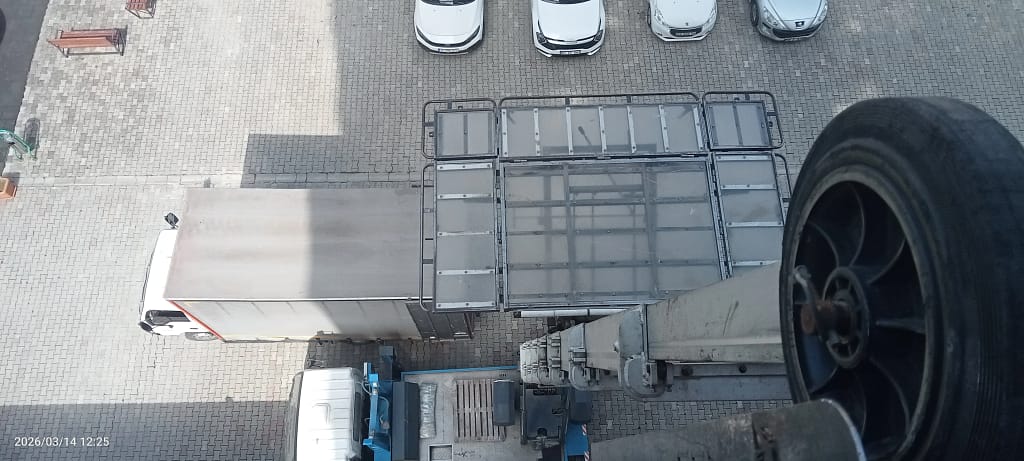 Trabzon Yomra asansörlü evden eve nakliyat nakliye asansöründen inen eşyaların direk arabaya yüklenmesini gösteren görsel bir nakliye kamyonu bir asansörlü vinç.