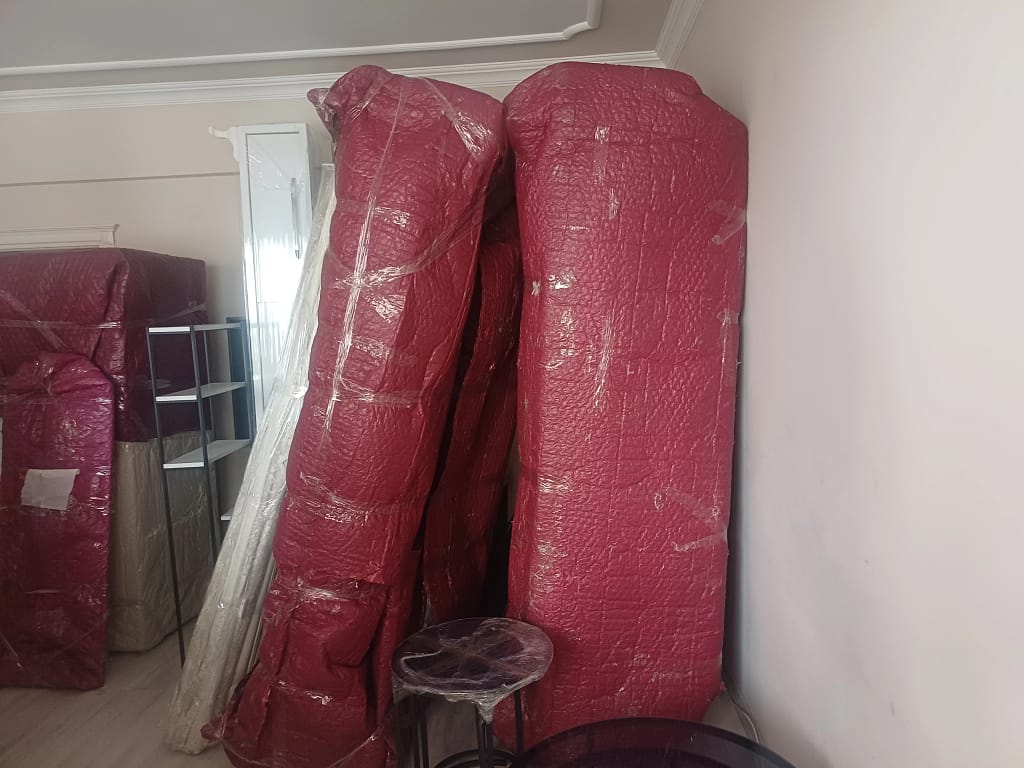 Trabzon Beşikdüzü evden eve nakliyat iki üçlü koltuk paketlenip diklenmiş duvara yaslanmış